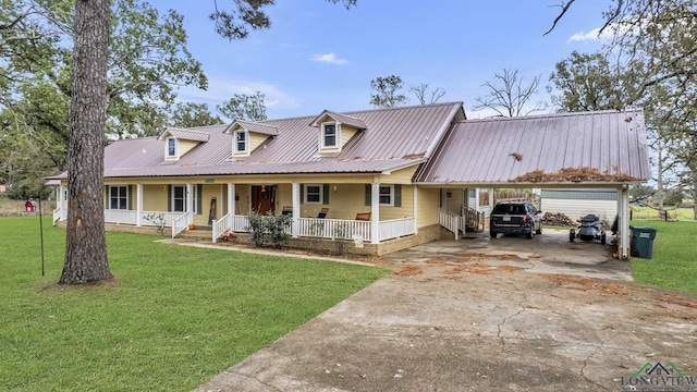 cape cod house with a front lawn, covered porch, and a carport