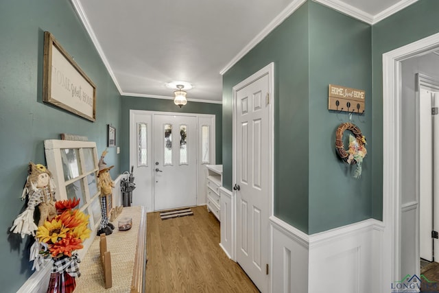 foyer entrance with crown molding and light hardwood / wood-style flooring