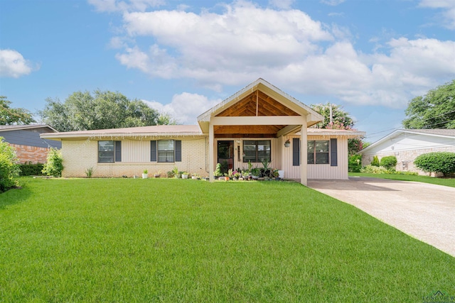 1605 Clearwood Dr, Longview, TX 75604 - view of front of house featuring a front yard, brick siding, board and batten siding, and concrete driveway