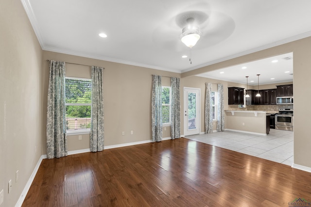 107 Lakeway Ln, Longview, TX 75604 - unfurnished living room featuring healthy amount of natural light, ceiling fan, light wood-style floors, ornamental molding, and baseboards
