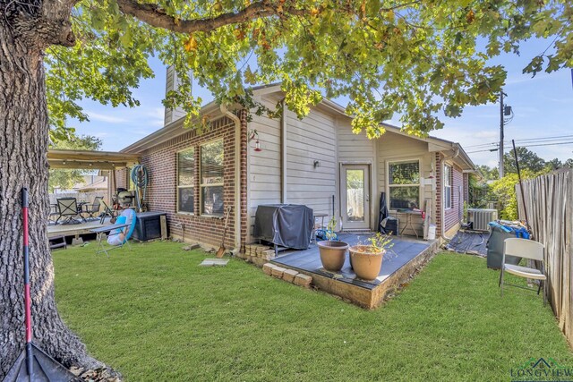 406 Alta St, Longview, TX 75604 - back of house featuring central AC, fence, brick siding, a patio area, and a lawn