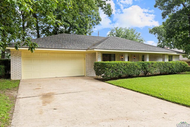 1205 Tiffany Ln, Longview, TX 75604 - ranch-style house with brick siding, an attached garage, a front yard, and concrete driveway