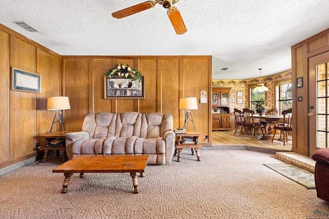 1205 Tiffany Ln, Longview, TX 75604 - carpeted living area featuring ceiling fan, a textured ceiling, and wood walls