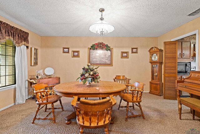1205 Tiffany Ln, Longview, TX 75604 - dining space featuring a chandelier, light colored carpet, and a textured ceiling