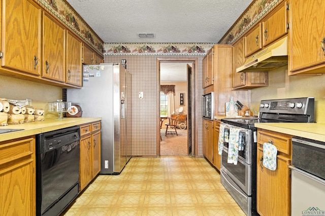 1205 Tiffany Ln, Longview, TX 75604 - kitchen featuring double oven range, dishwashing machine, under cabinet range hood, light countertops, and a textured ceiling
