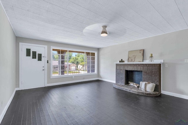 1207 Lettie St, Longview, TX 75601 - unfurnished living room featuring dark wood-style flooring, a fireplace, and baseboards