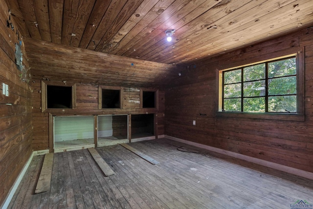 1207 Lettie St, Longview, TX 75601 - empty room featuring wooden ceiling, wood walls, wood-type flooring, and baseboards