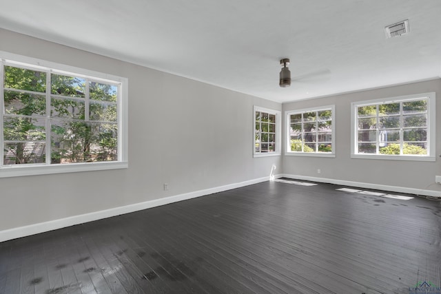 1207 Lettie St, Longview, TX 75601 - spare room featuring healthy amount of natural light, baseboards, ceiling fan, and dark wood finished floors