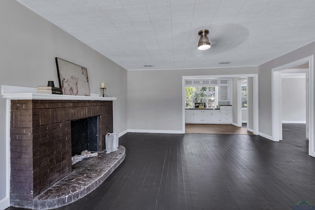 1207 Lettie St, Longview, TX 75601 - living area with a fireplace, dark wood-type flooring, and baseboards