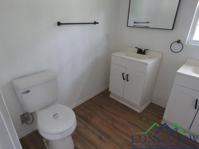 bathroom featuring vanity, hardwood / wood-style flooring, and toilet