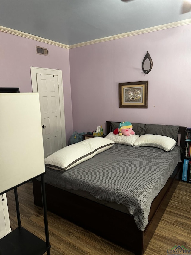 bedroom featuring ornamental molding and dark wood-type flooring