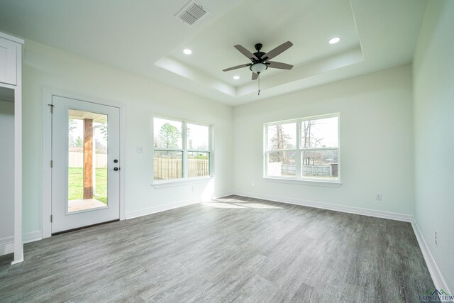 spare room featuring hardwood / wood-style flooring, a raised ceiling, and ceiling fan