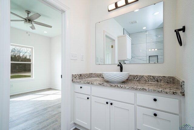 bathroom with wood-type flooring, vanity, and ceiling fan