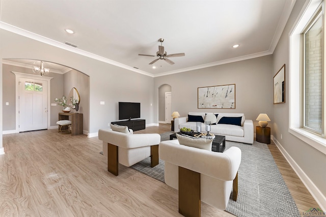 living room featuring ceiling fan with notable chandelier, light hardwood / wood-style floors, and crown molding