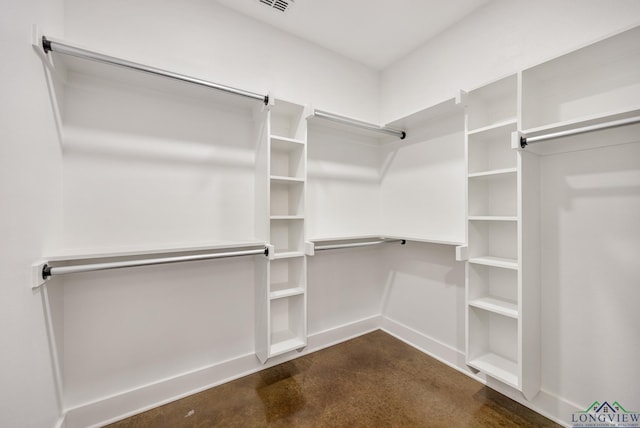 spacious closet with dark colored carpet