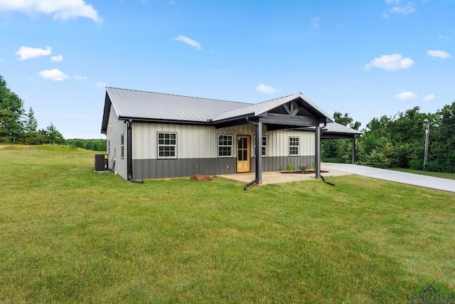 view of front of home featuring a front yard and central AC