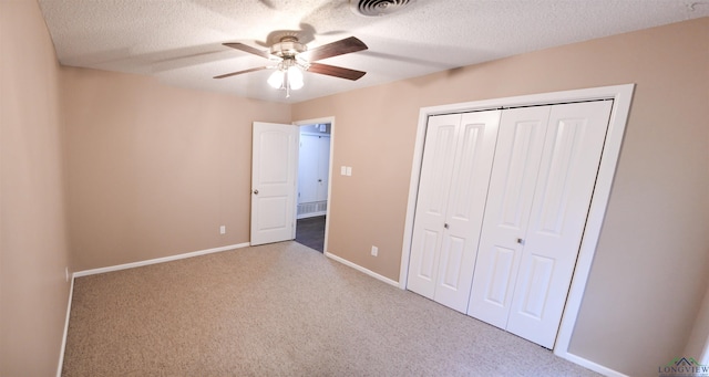 unfurnished bedroom featuring light carpet, a textured ceiling, ceiling fan, and a closet