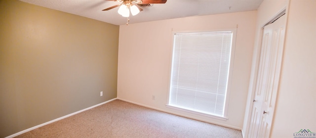 carpeted empty room featuring ceiling fan