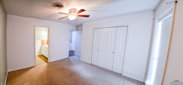 unfurnished bedroom with connected bathroom, a textured ceiling, a closet, and ceiling fan