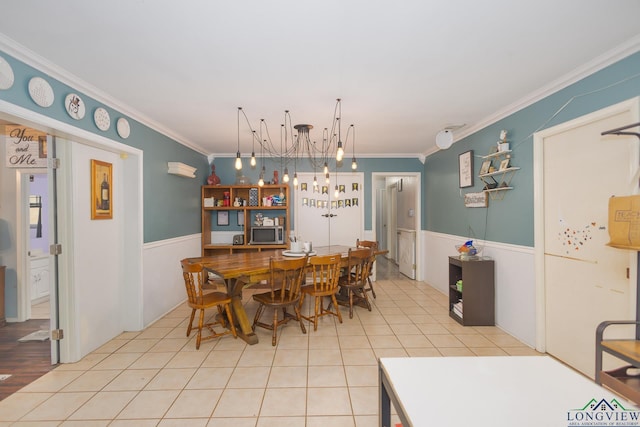 604 Kay Ct, Longview, TX 75601 - tiled dining room with crown molding, a wainscoted wall, and a chandelier