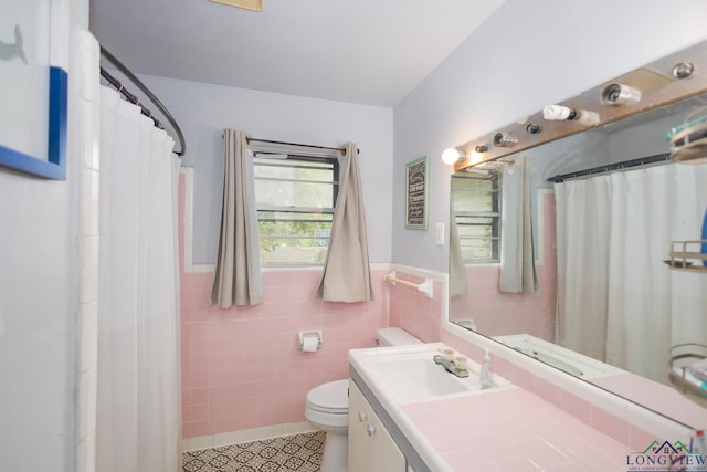 604 Kay Ct, Longview, TX 75601 - full bathroom featuring tile walls, tile patterned flooring, vanity, wainscoting, and curtained shower