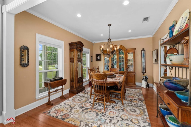dining room with crown molding, baseboards, wood finished floors, and a chandelier