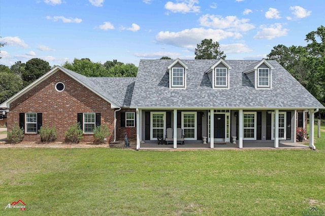 cape cod house featuring brick siding, a shingled roof, and a front yard