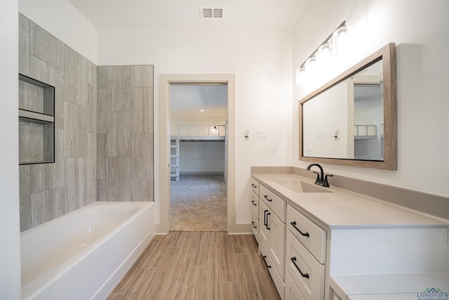 bathroom featuring washtub / shower combination and vanity