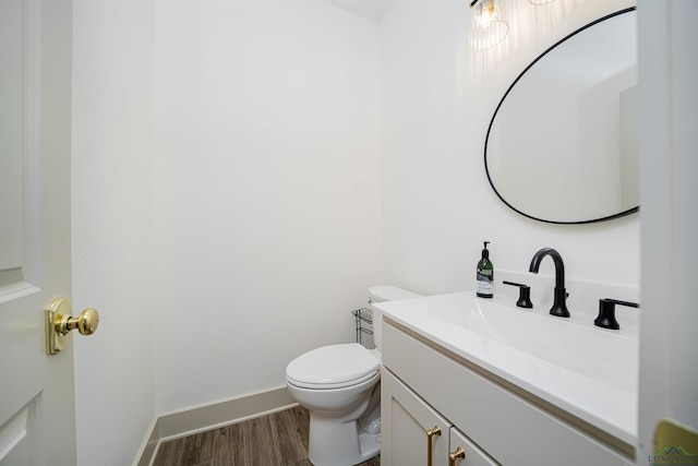 bathroom with hardwood / wood-style flooring, vanity, and toilet