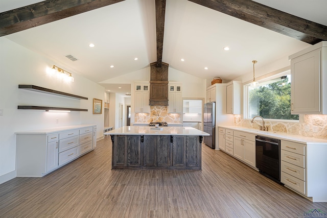 kitchen featuring tasteful backsplash, stainless steel fridge, a large island, and black dishwasher