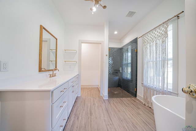 bathroom with shower with separate bathtub, vanity, and hardwood / wood-style flooring