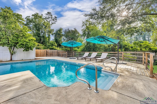 1900 W Hoyt Dr, Longview, TX 75601 - view of pool featuring a fenced backyard, view of wooded area, a deck, and a patio area