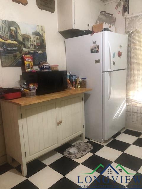 kitchen with white fridge and white cabinetry