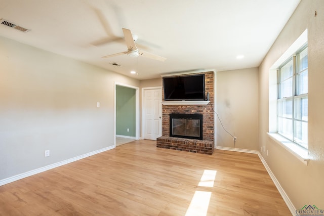 unfurnished living room with light hardwood / wood-style flooring, a fireplace, and ceiling fan