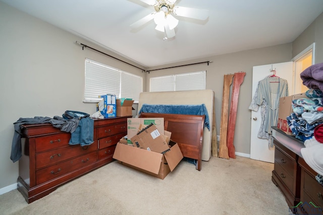 bedroom featuring baseboards, light colored carpet, and a ceiling fan