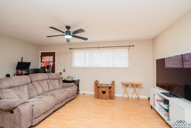 living room featuring light wood-type flooring, baseboards, and ceiling fan