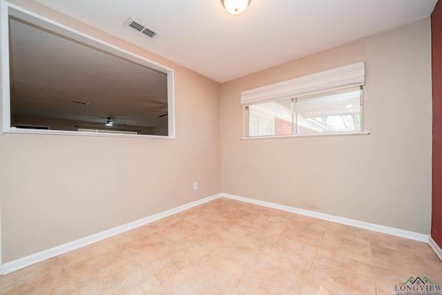 empty room featuring baseboards and visible vents