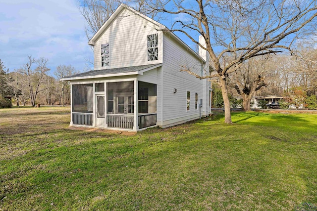 back of house with a yard and a sunroom