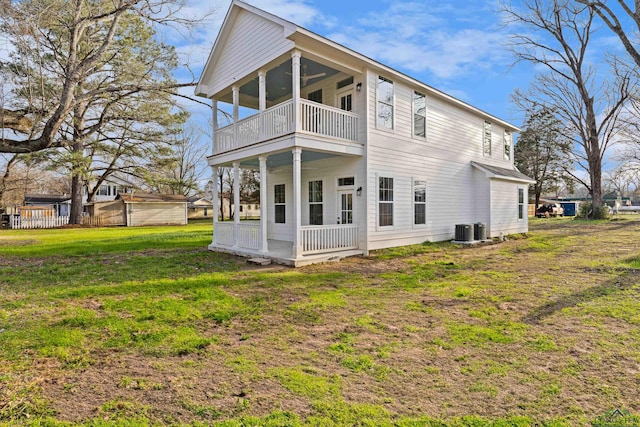 back of property with a porch, a balcony, a yard, central AC unit, and ceiling fan