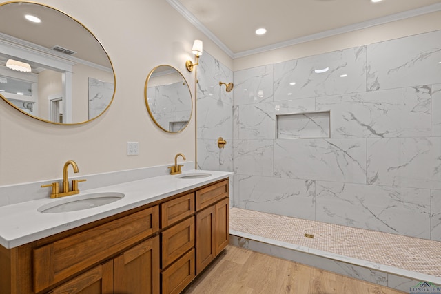 bathroom featuring vanity, hardwood / wood-style floors, crown molding, and tiled shower