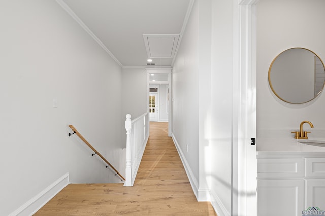 hall with crown molding, sink, and light hardwood / wood-style flooring