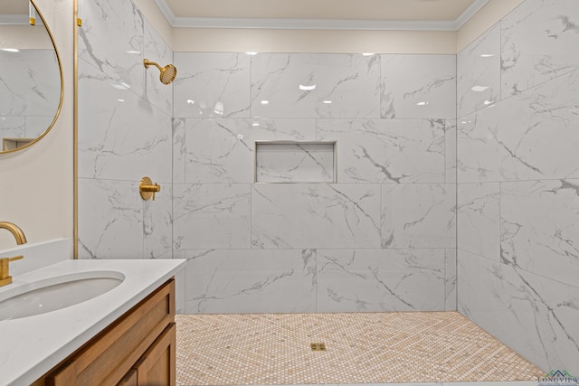 bathroom featuring tiled shower, ornamental molding, and vanity