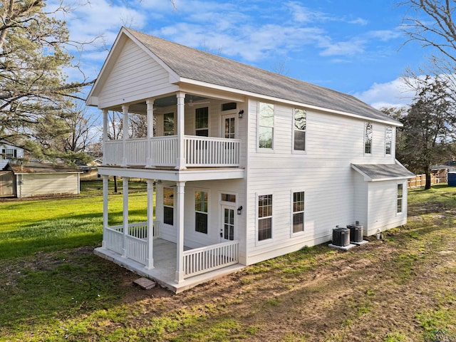 rear view of house with central AC, a porch, a yard, and a balcony