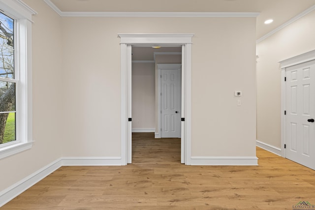 spare room featuring crown molding and light wood-type flooring