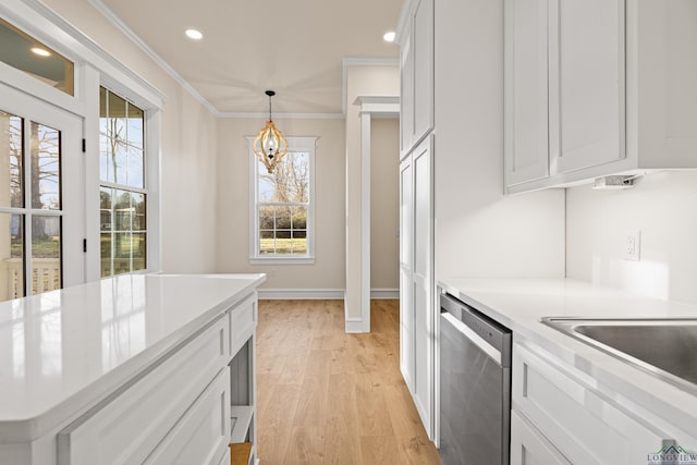 kitchen featuring stainless steel dishwasher, ornamental molding, pendant lighting, light hardwood / wood-style floors, and white cabinets