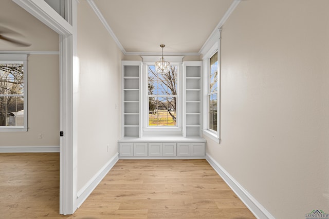 unfurnished dining area with crown molding, a chandelier, and light hardwood / wood-style flooring