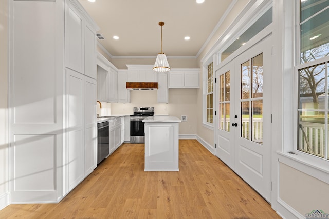 kitchen with appliances with stainless steel finishes, a center island, hanging light fixtures, and white cabinets