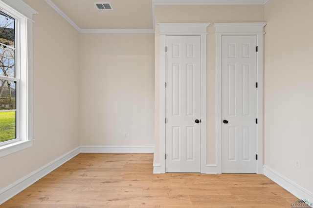 unfurnished bedroom with ornamental molding and light wood-type flooring