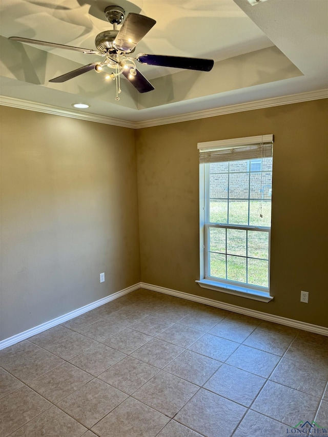 tiled spare room with ceiling fan, ornamental molding, and a raised ceiling