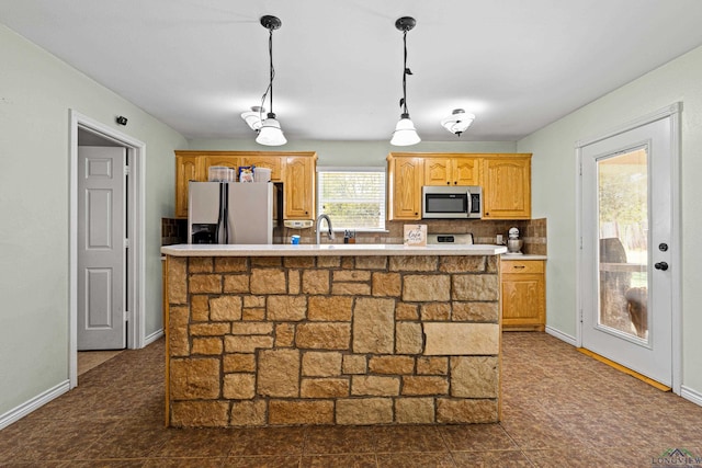 kitchen with pendant lighting, sink, stainless steel appliances, and a center island